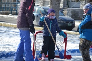 Kids and adults playing outdoor ice hockey